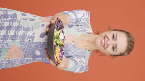 Vertical-video-of-The-person-holding-a-plate-of-salad-is-laughing.